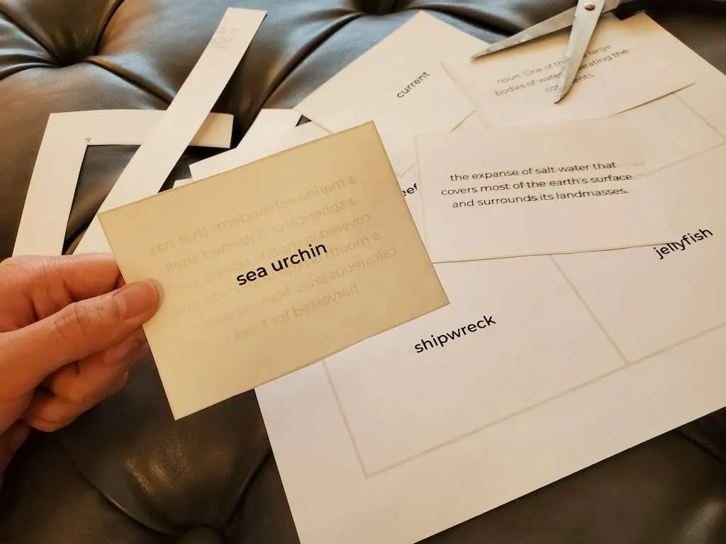 hand holding a flashcard with other cards laid out on a table