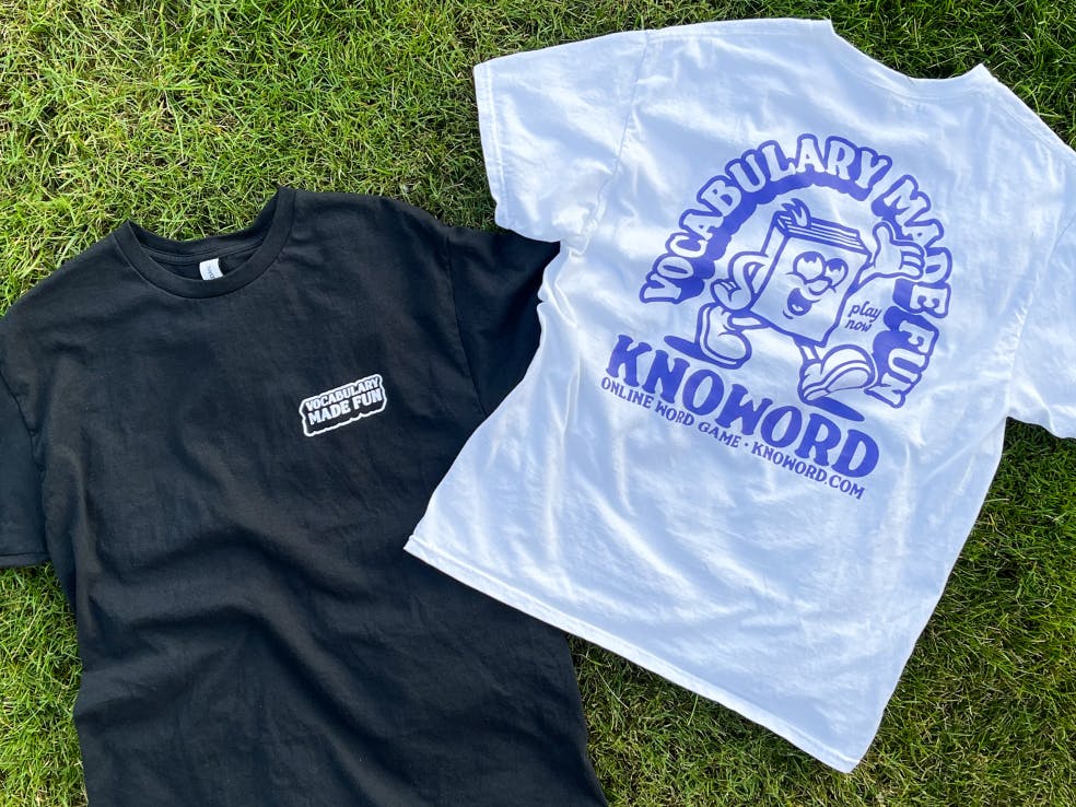 two knoword shirts, a black one and a white one, laying on the grass